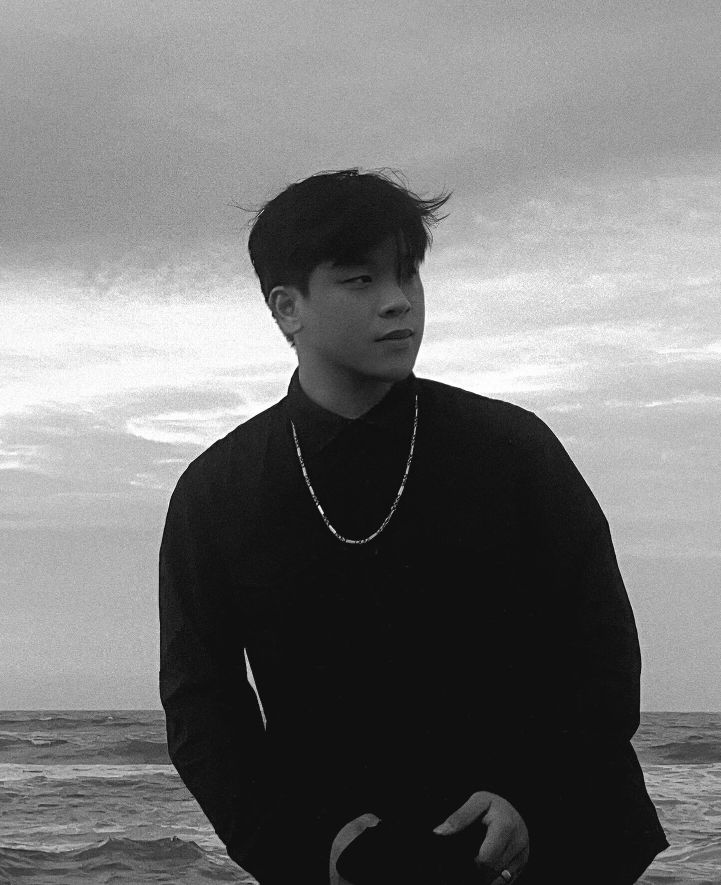 Portrait of a man with brown hair and glasses on a flat gray background.